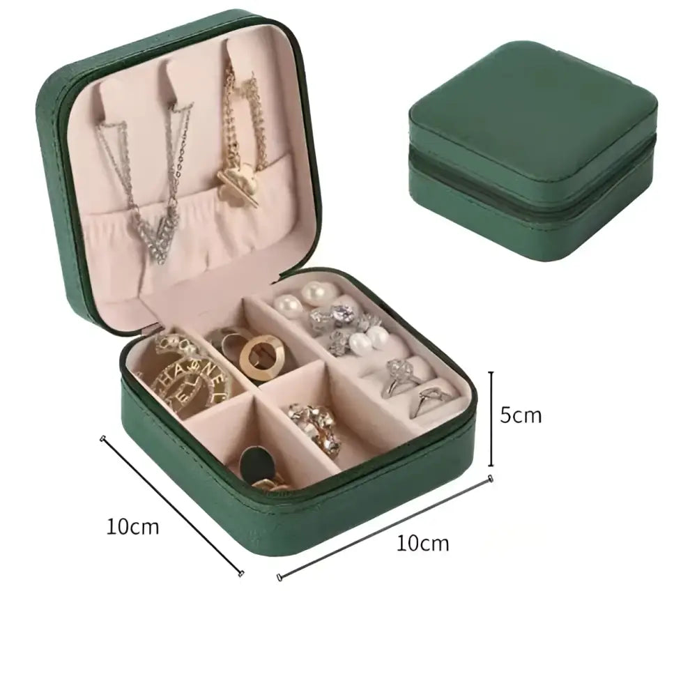 Green textured leather jewelry box with pink compartments shown inside black wall mounted portable women makeup bag