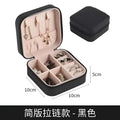 Black wall mounted portable women makeup bag in black leatherette with pink interior compartments and zipper closure