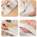 A light gray compact travel organizer with transparent mesh pockets and zipper for black wall mounted portable women makeup