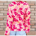 A blooming floral print long-sleeved hoodie with vibrant pink and peach colors and soft cozy fabric texture