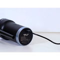 Black opolar household mini vacuum with silver accent ring and charging cable plugged into its base