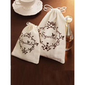 Cream-colored drawstring gift bags with black floral embroidery and special script for blue butterfly mori style shark clip