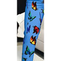 Blue butterfly slim fit pants feature blue leggings with a vibrant all over print of colorful butterflies