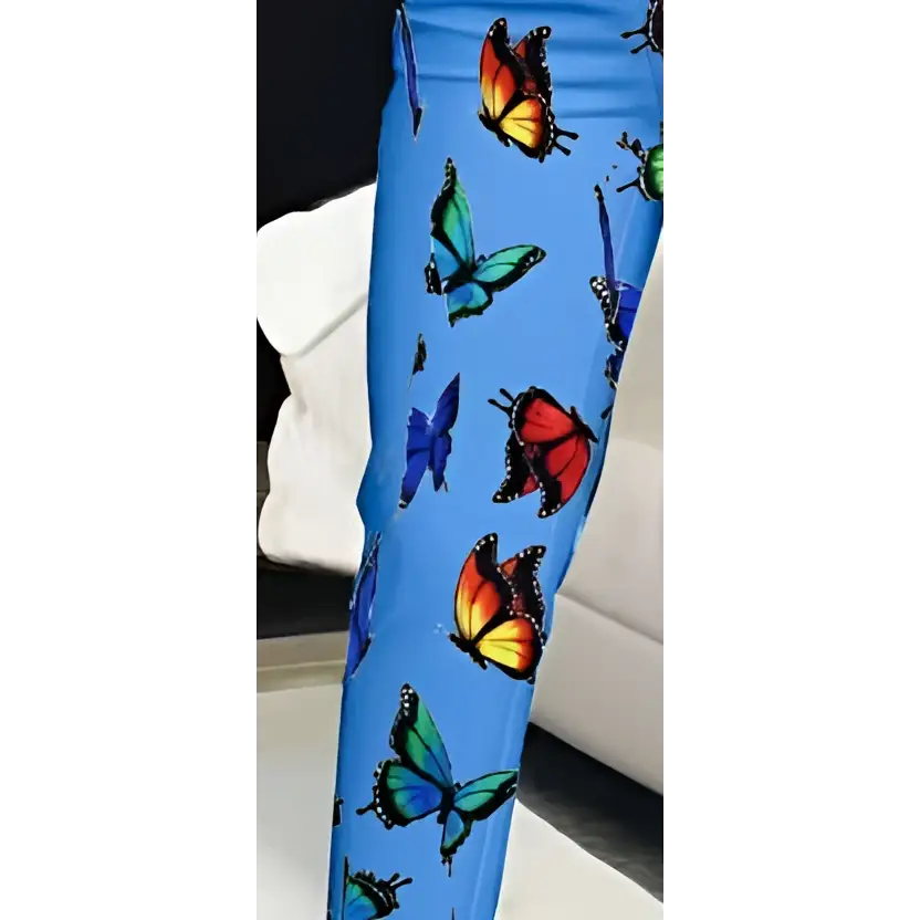 Blue butterfly slim fit pants feature blue leggings with a vibrant all over print of colorful butterflies