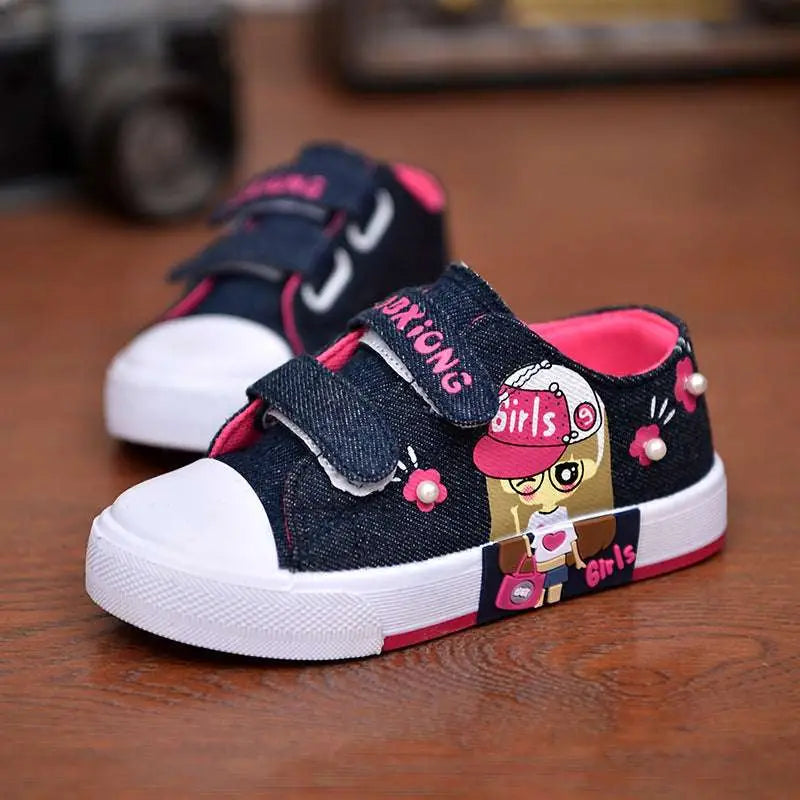 Blue denim girls canvas shoes with cartoon girl design featuring pink velcro straps and white rubber toe caps