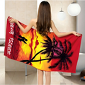 A vibrant red printed beach towel with black palm trees and tropical sunset design featuring sands of hawaii text