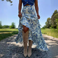A flowing blue floral split print pleating big hem skirt made of lightweight fabric with a high low silhouette