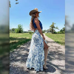 A woman wears a white blue floral split print pleating big hem skirt with layered ruffles paired with a navy crop top