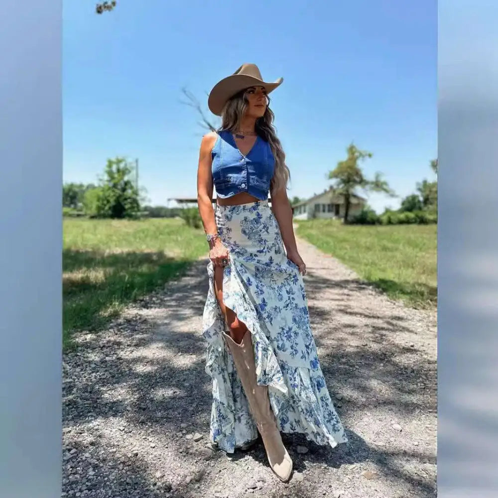 Woman wearing a white floral big hem skirt with blue floral split print pleating paired with beige cowboy boots and tan hat