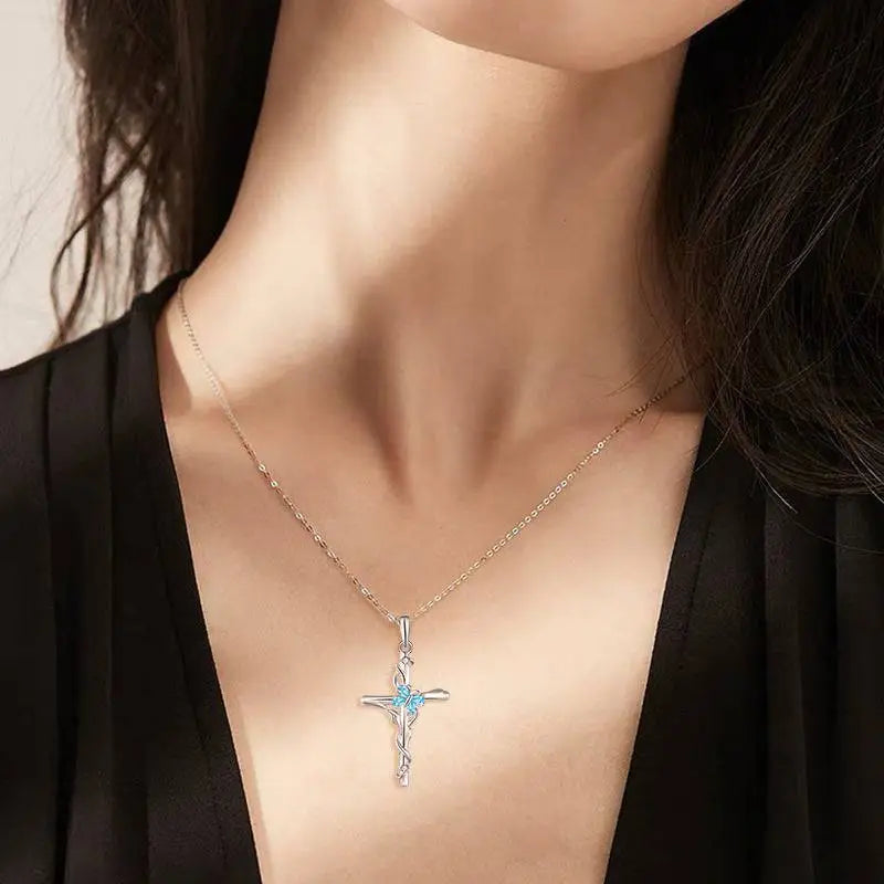 Delicate sterling silver women necklace featuring a blue gemstone cross pendant on an elegant gold-toned chain