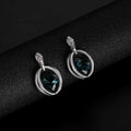 Silver hoop earrings featuring a deep teal blue gemstone and clear crystals in a crystal bridal necklace earrings set