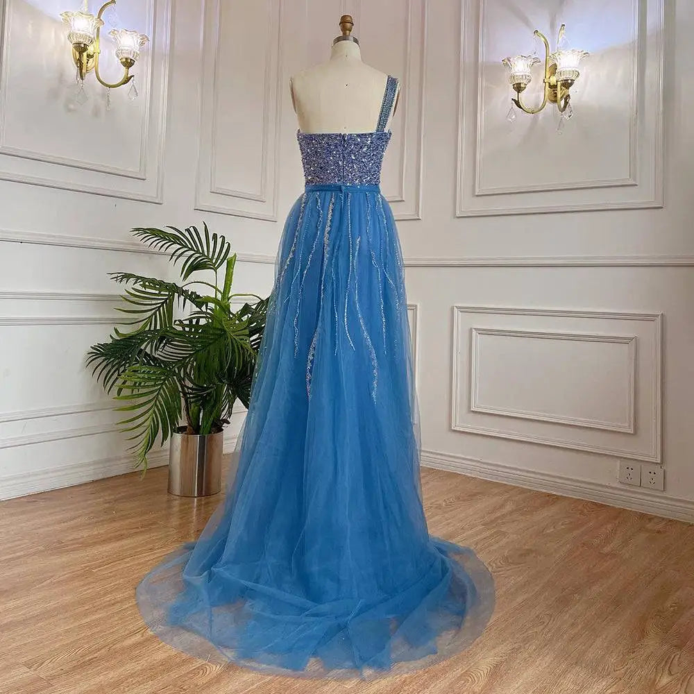 A shimmering royal blue handmade beaded split shoulder fishtail evening gown with a flowing tulle skirt