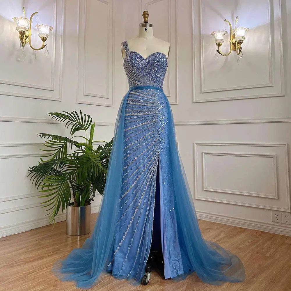 A shimmering light blue handmade beaded split shoulder fishtail evening gown with heart-shaped bodice on mannequin