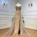 A shimmering gold handmade beaded evening gown with a sweetheart neckline and flowing sheer train