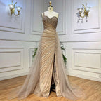 A shimmering gold handmade beaded evening gown with a sweetheart neckline and flowing sheer train