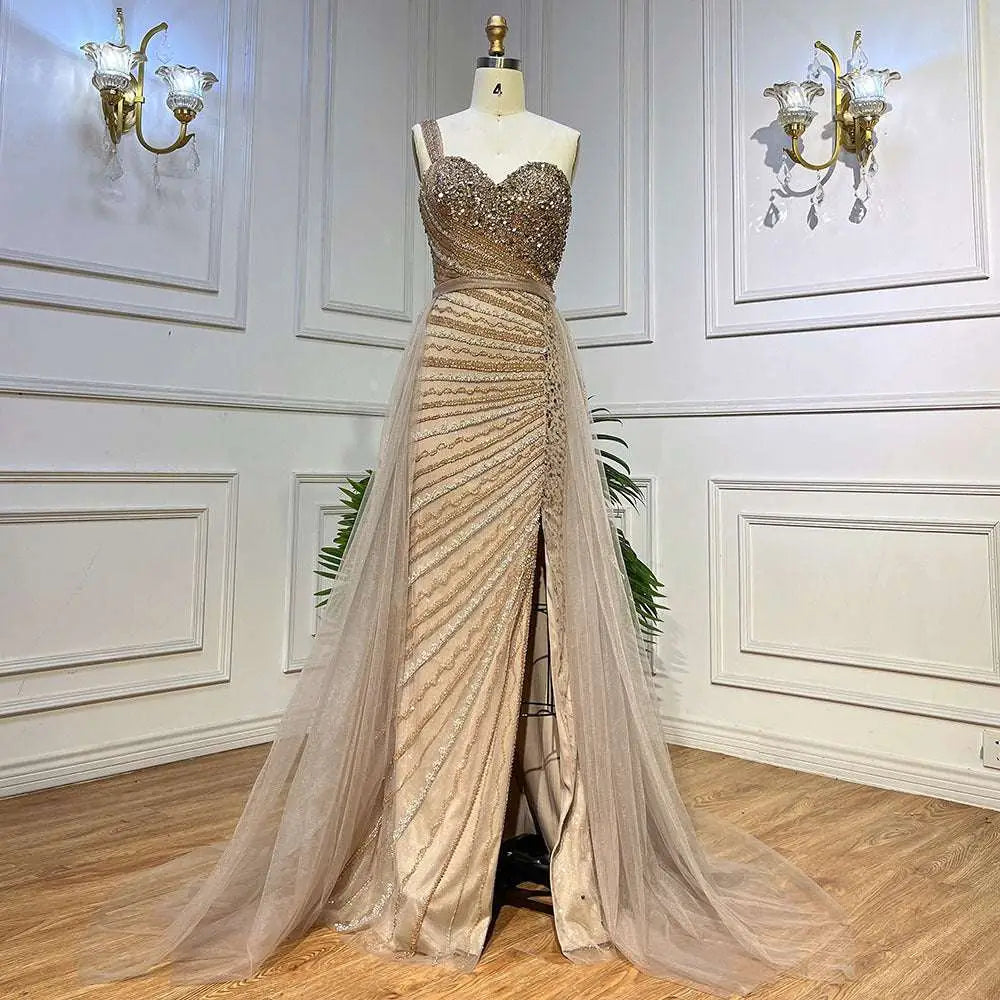 A shimmering gold handmade beaded evening gown with a sweetheart neckline and flowing sheer train