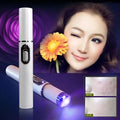 White cylindrical blue light therapy acne laser pen with silver button and glowing purple tip for acne treatment