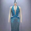 Back view of a shimmering turquoise sequined halter neck gown with deep v back and cinched waist for slimming party stage host use