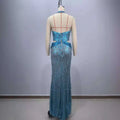 A shimmering turquoise sequined slimming party stage mermaid gown with halter neckline and back cutouts