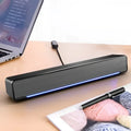 Black rectangular bluetooth dual-mode soundbar with textured fabric grille and glowing blue led strip upgrade