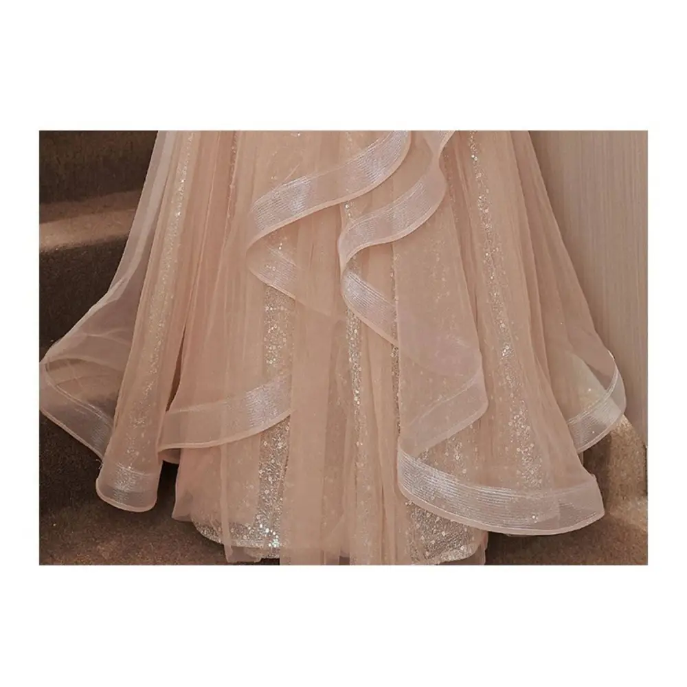 A blush beaded tulle luxury evening dress with delicate blush pink fabric and shimmering champagne-colored blush accents