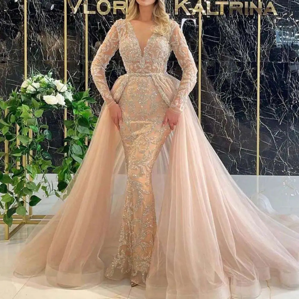 Blush pink beaded mermaid style wedding dress with long sheer lace sleeves and intricate silver beading on bodice