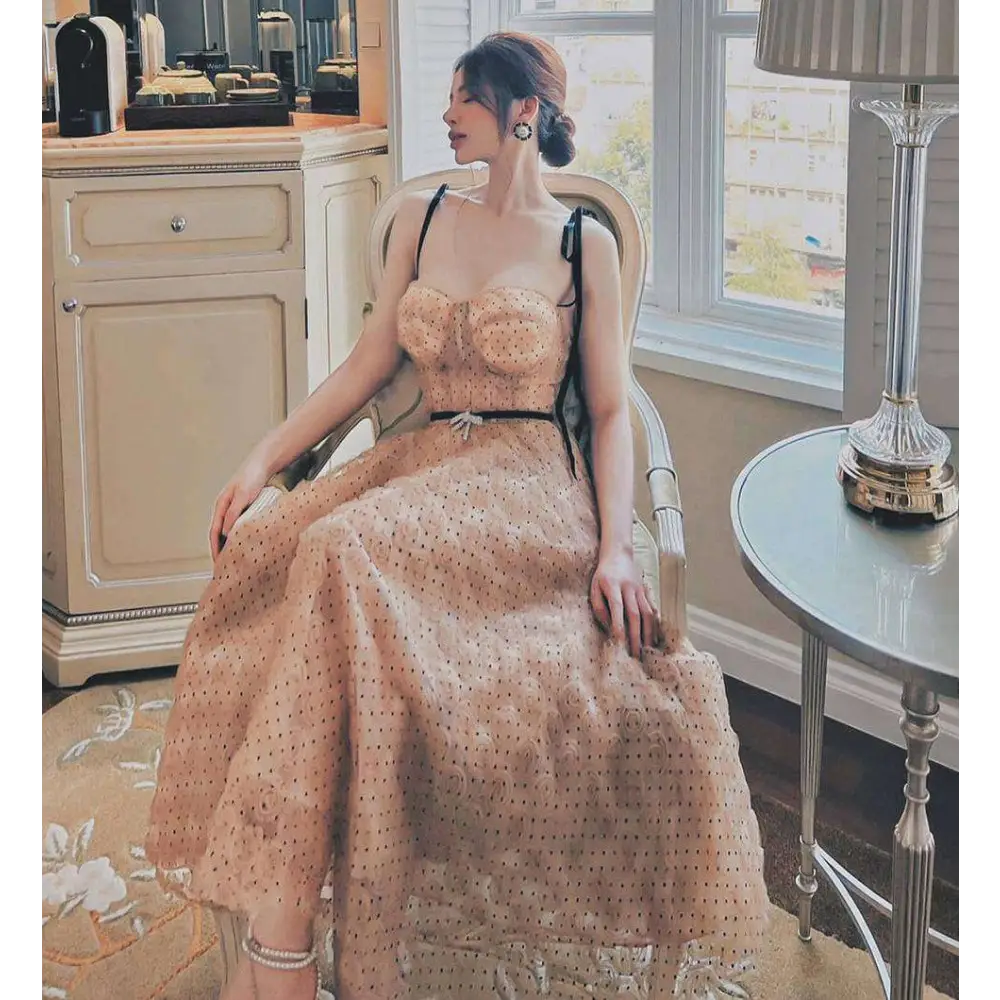 A blush pink lace slim drawstring gown with black polka dots featuring a fitted bodice and flowing skirt