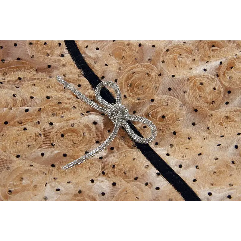 A sparkling silver bow brooch with rhinestones on blush pink lace slim drawstring dress with black polka dots