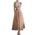 A blush pink lace slim drawstring midi dress with sweetheart neckline black straps and matching black belt bow