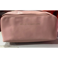 A blush pink large travel cosmetic bag made of soft leather with an embossed rose of no mans land logo