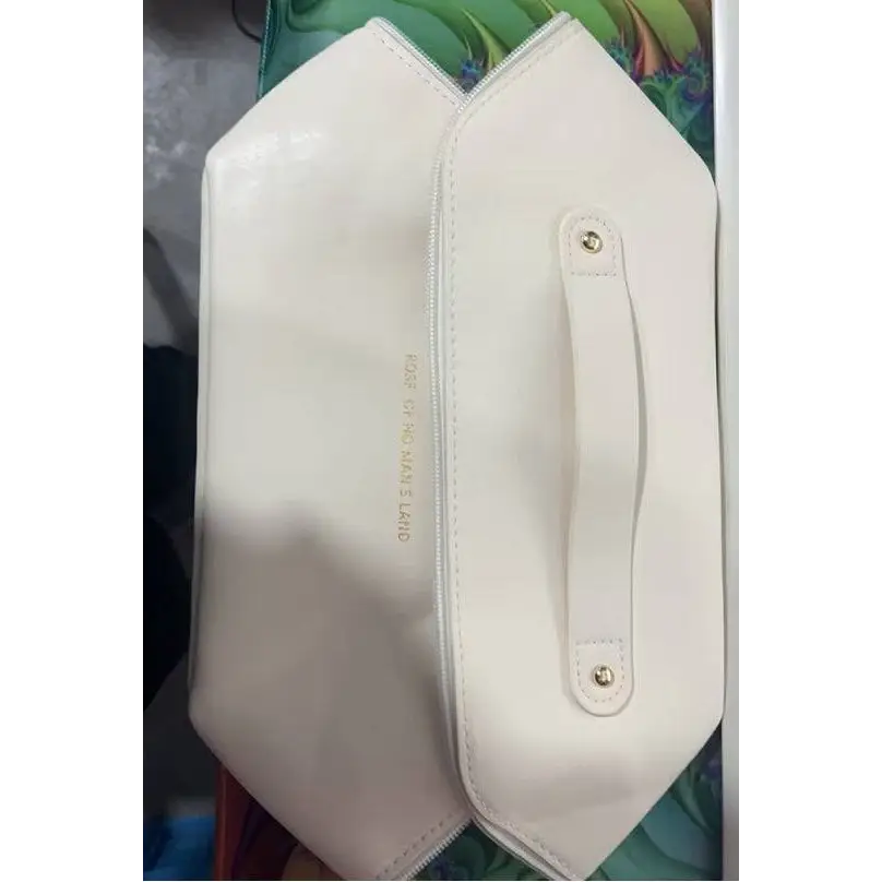 A sleek white leather travel cosmetic bag with a central handle and gold hardware for blush pink large makeup storage