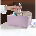 A blush pink large travel cosmetic bag with soft lavender texture and subtle gold-lettered inscription on front