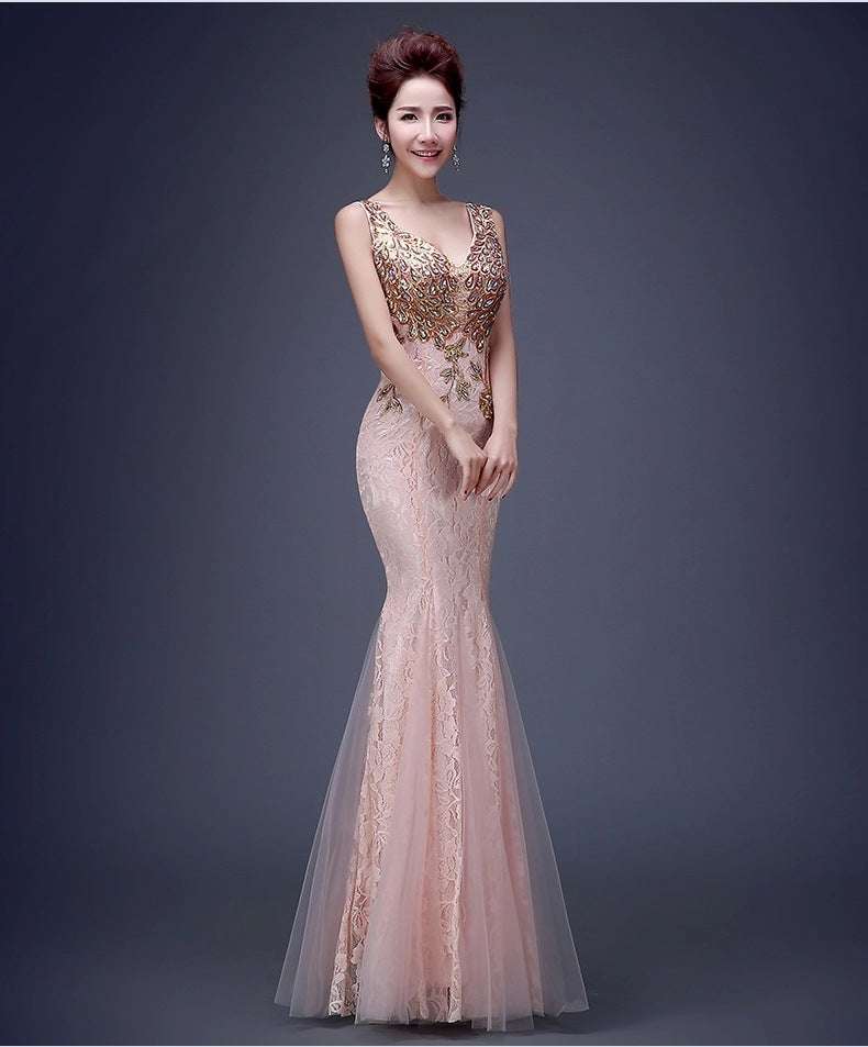 a blush pink mermaid-style evening gown with intricate gold lace detailing and a sheer tulle overlay suitable for a bridal party wedding dress or flower girl outfit
