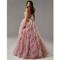 A flowing blush pink mesh gown prom with a deep back and layered ruffles perfect for evening gown prom events