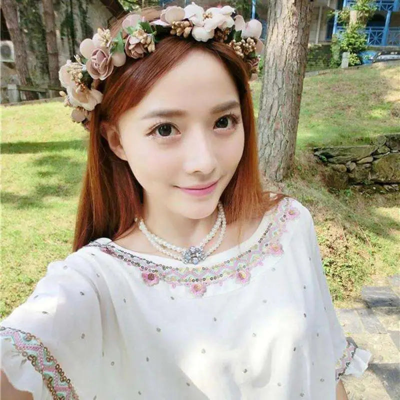Blush rose wedding garland flower crown featuring a delicate headband with pink cream blossoms green leaves and gold accents