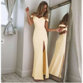 A flowing pale yellow blush satin luxury fashion tube dress with off-the-shoulder design and high slit silhouette