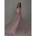 A blush pink sequined backless evening dress with fitted bodice and flowing glitter-dusted skirt