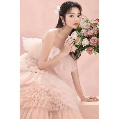 A blush pink strapless photography pettiskirt colored mesh dress with layered ruffles and a voluminous skirt