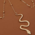 Bohemian boho gold snake leg chain jewelry featuring a gold-toned textured scaly surface with black bead eyes
