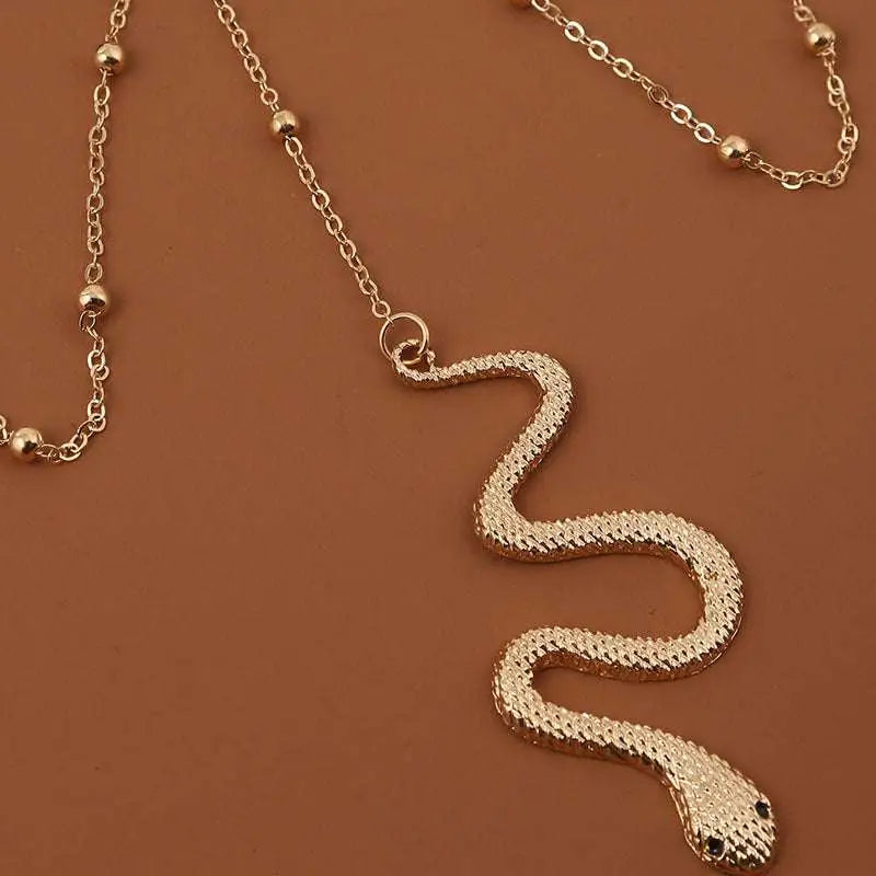 Bohemian boho gold snake leg chain jewelry featuring a gold-toned textured scaly surface with black bead eyes