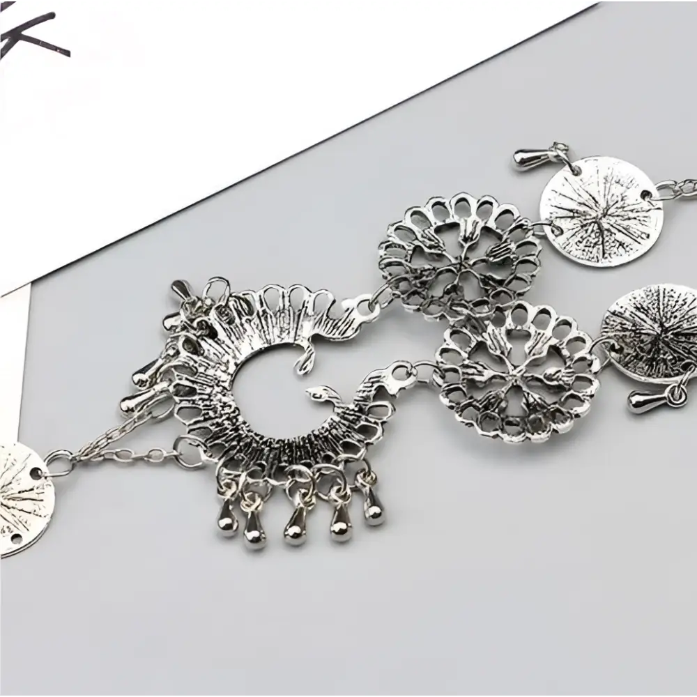 Silver-toned bohemian jewelry antique flower foot chain featuring intricate peacock filigree and dangling bead accents