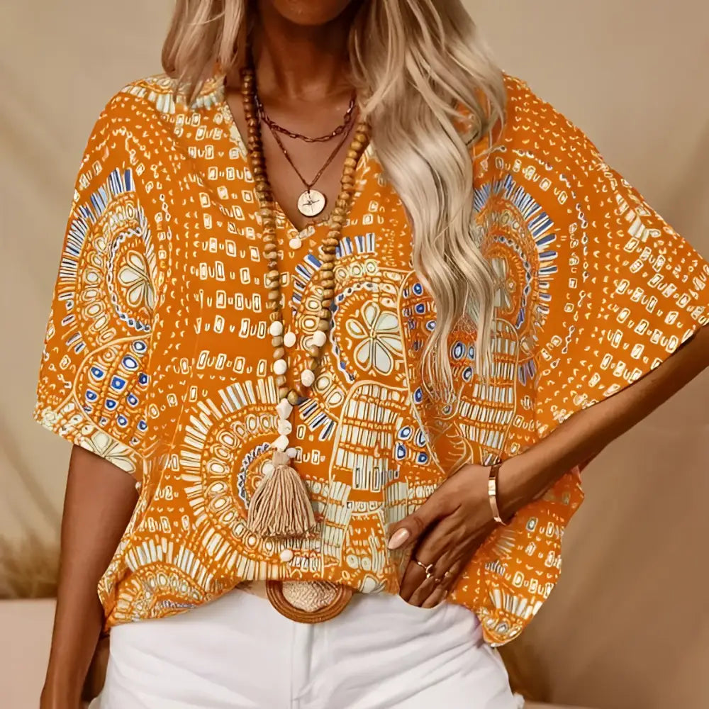 Vibrant orange bohemian-patterned top with white and blue geometric patterns and style batwing sleeve design