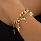 Gold-toned chain bracelet with dolphin seashell and crescent moon charms in conch dolphin starfish necklace bracelet set