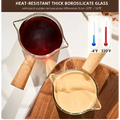Clear borosilicate glass espresso measuring cups with wood handle filled with dark red and light beige liquid