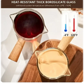 Clear borosilicate glass espresso measuring cups with wood handle filled with dark red liquid and light beige substance