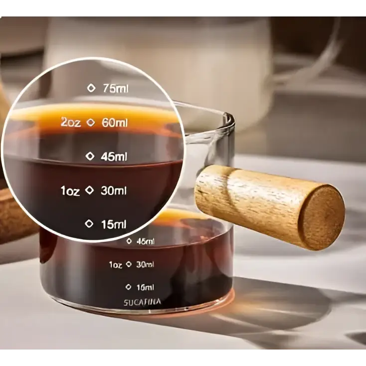 Borosilicate glass espresso measuring cup with wood handle and clear markings in milliliters and ounces