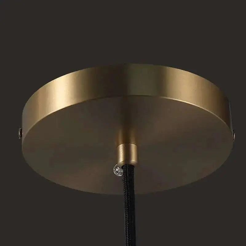 Brass and glass raindrop pendant light with brass finish, black braided cord, and crystal accent for contemporary elegance