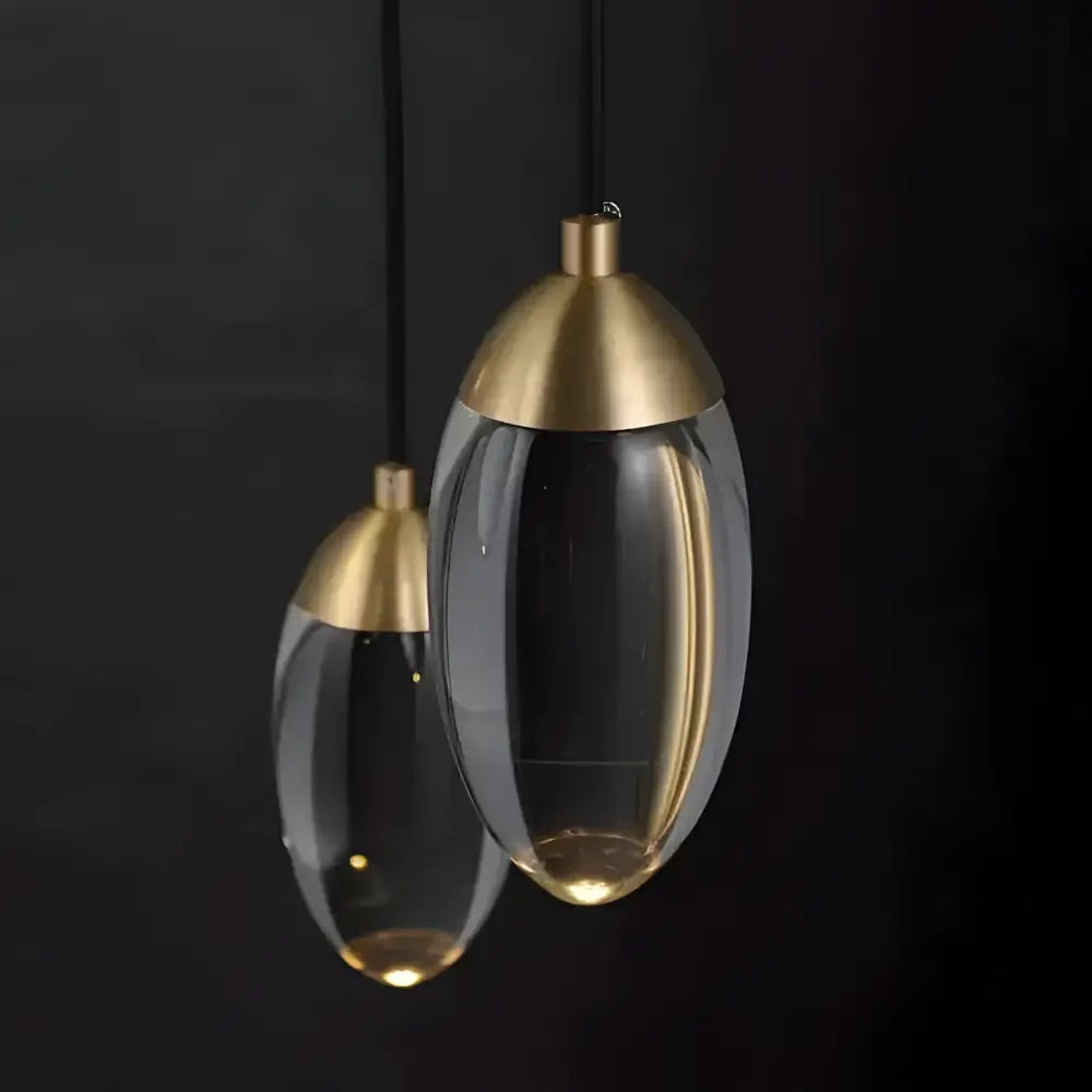 Brass and glass raindrop pendant lights featuring clear glass and gold-toned metal accents for contemporary elegance