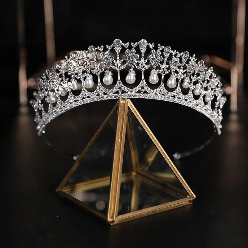 A sparkling silver bridal crown rhinestone tiara with intricate crystal work and dangling pearl drops