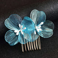 A delicate blue wirework bridal headdress with white center petals and gold-toned base fairy golden flower comb